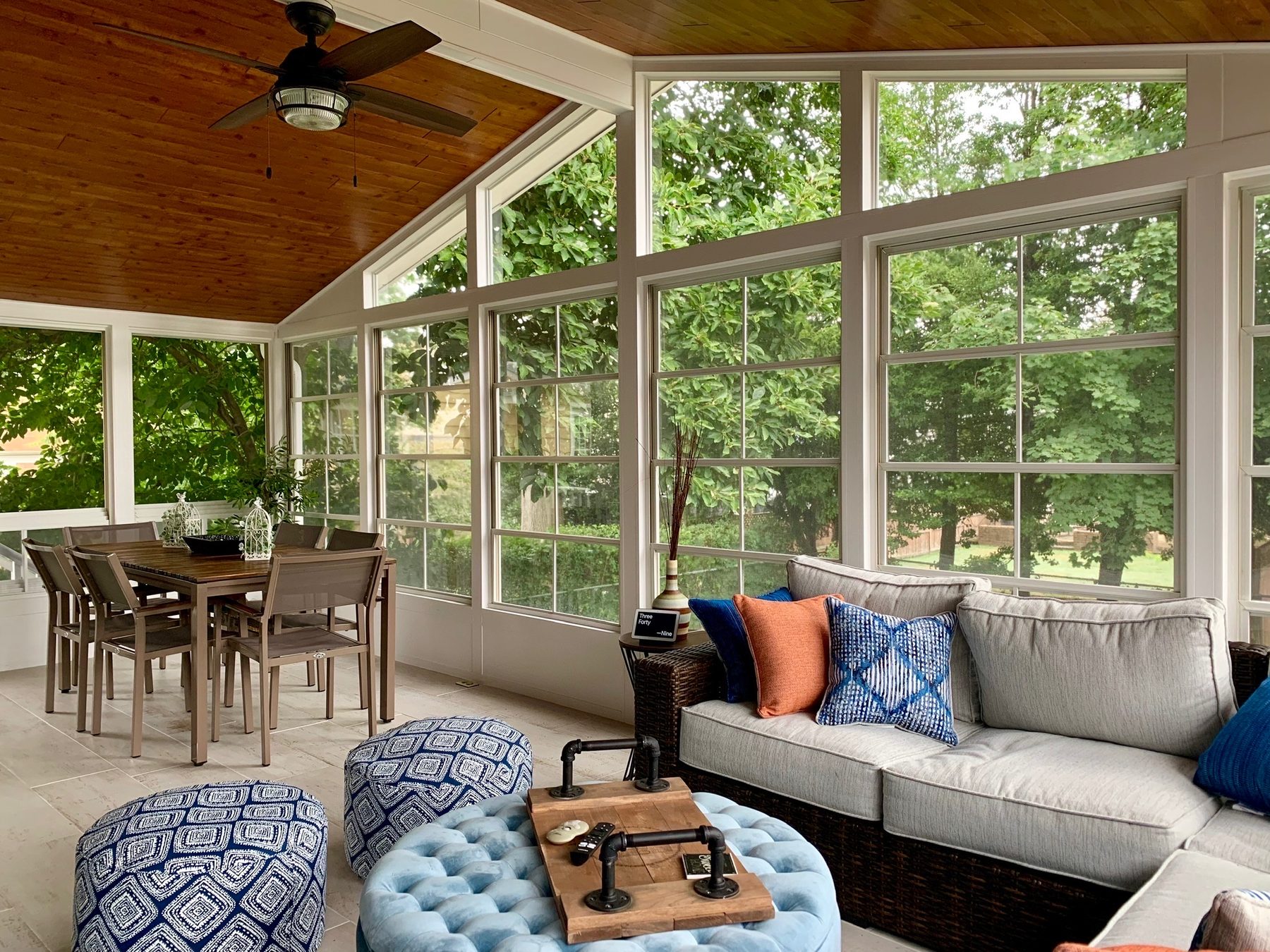 Three-season room with a wood-plank ceiling and ceiling fan