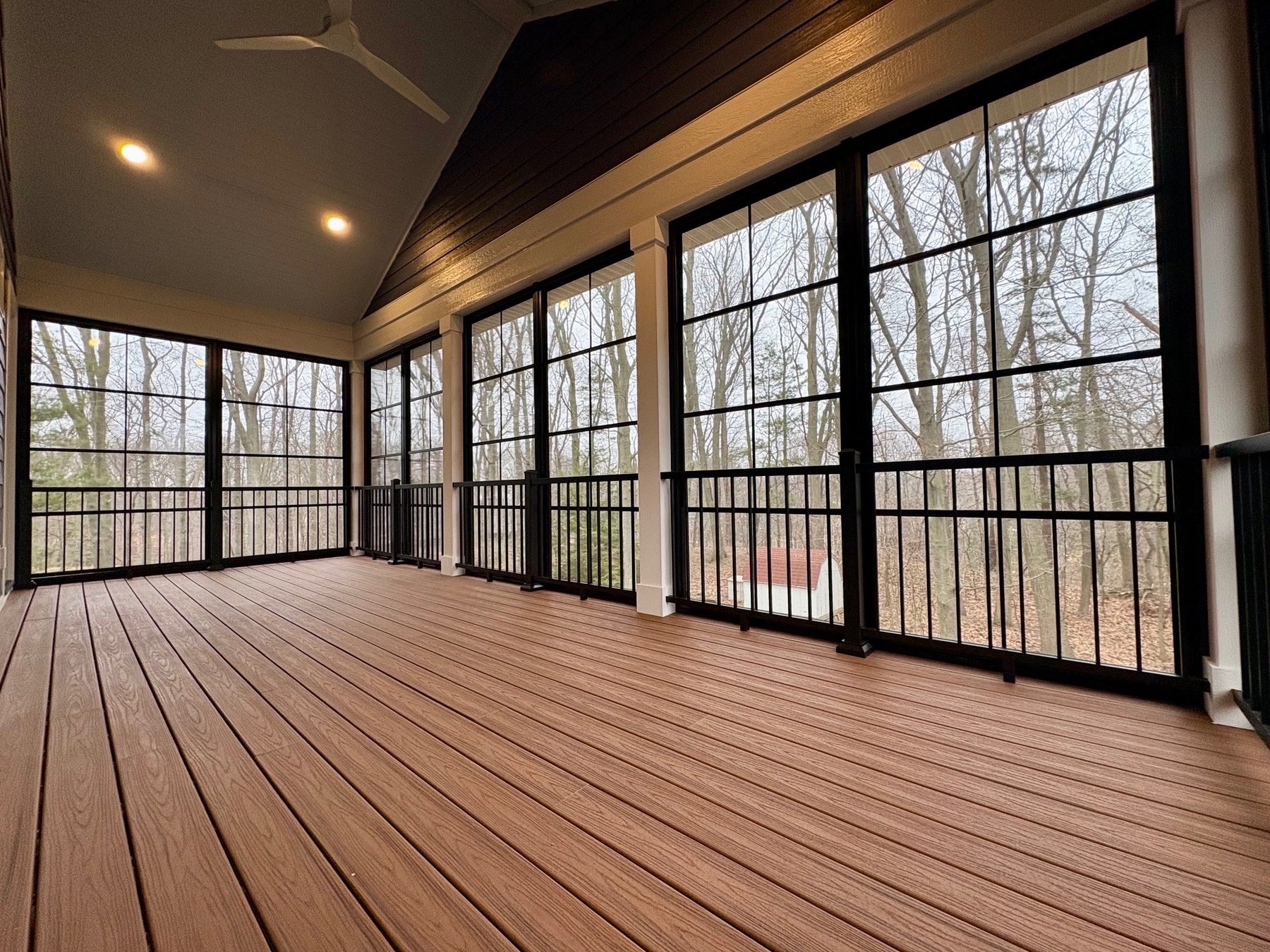Three-season room with a deck floor and vaulted ceiling