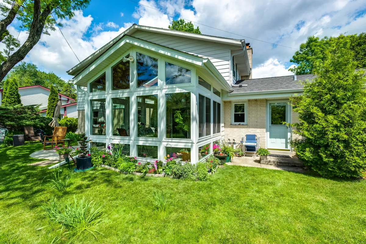 A-frame glass sunroom rising above a lush garden