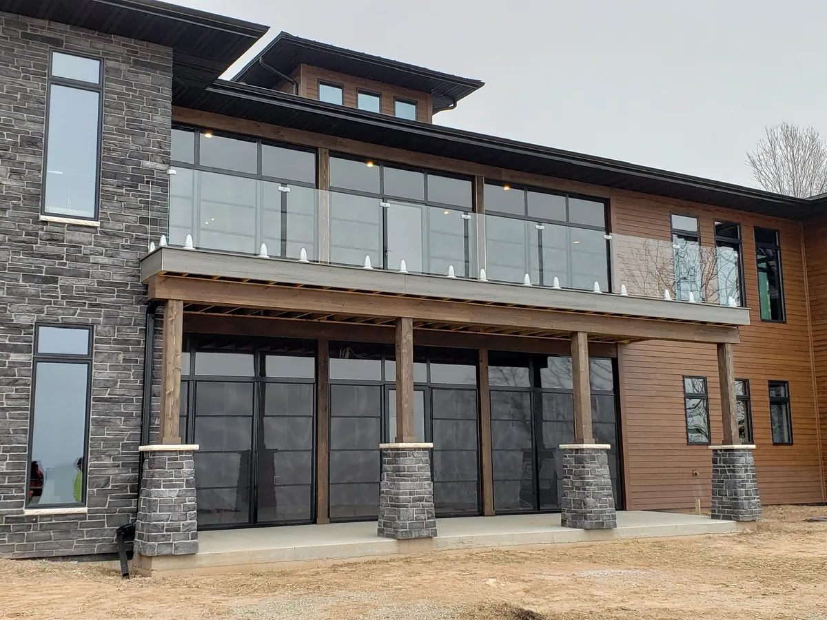 Modern multi-storey addition with glass railings and timber cladding