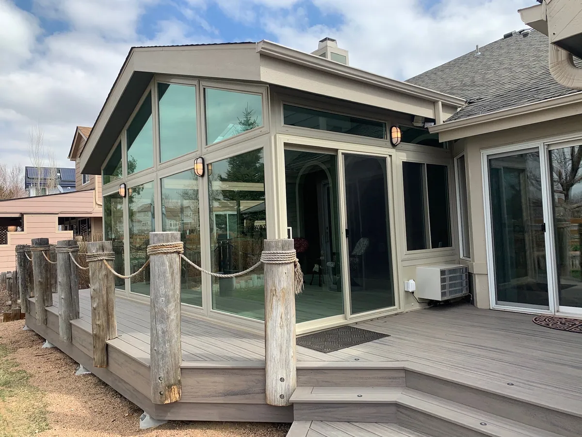 Gable-front glass sunroom on a raised deck framed by timber posts