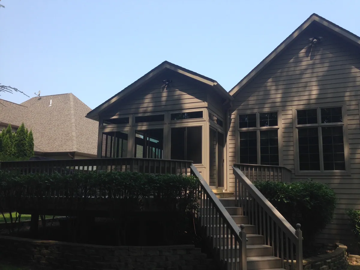Dark-framed room on a raised deck with a broad staircase