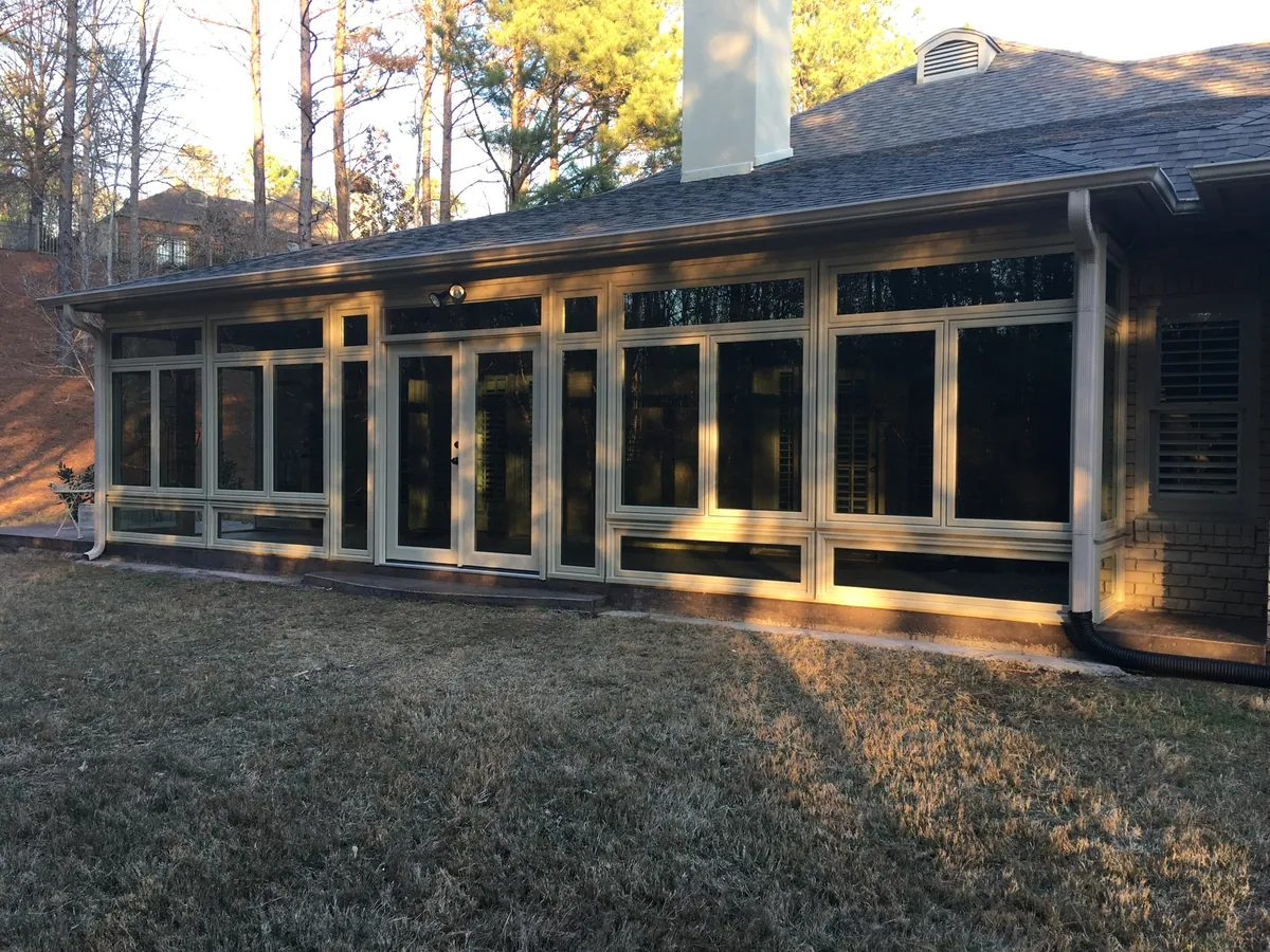 Long dark-framed sunroom catching golden evening light