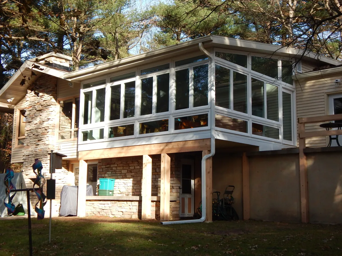 Sunroom set above a walkout patio on a two-level home