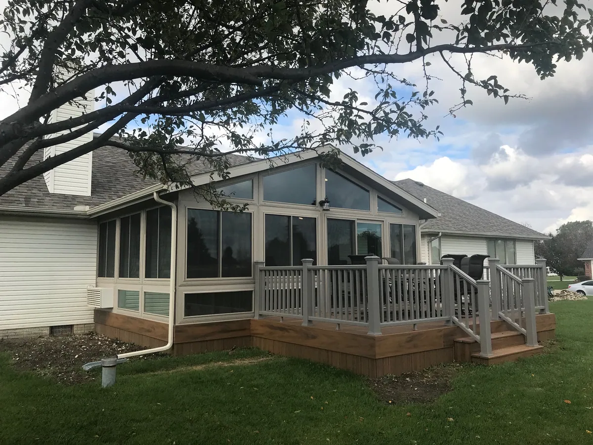 Sunroom and railed deck under mature shade trees