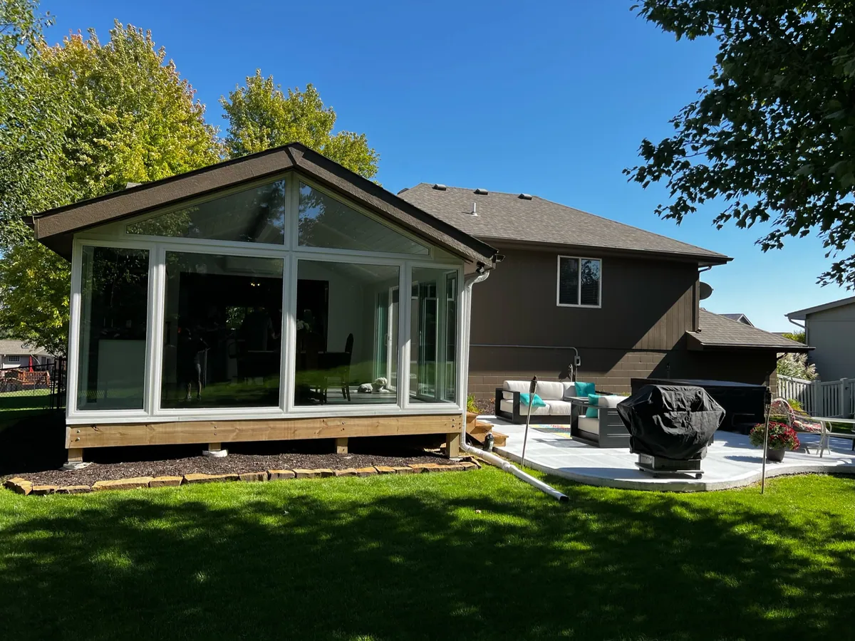 Gable sunroom opening onto a furnished patio