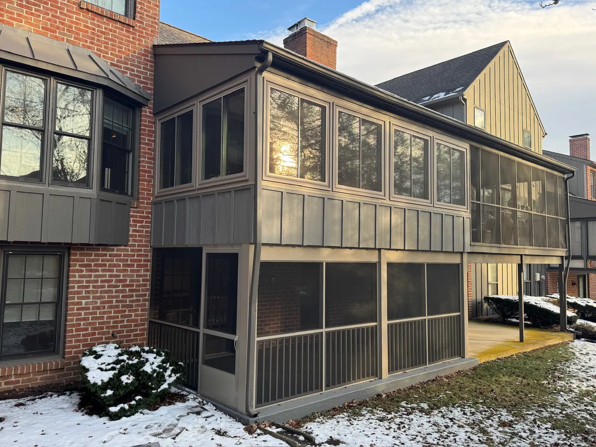 Two-storey screened porch on a brick home after the first snow