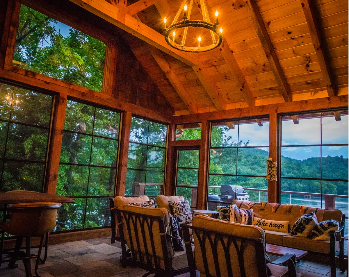 Timber-frame room with a chandelier and treetop views