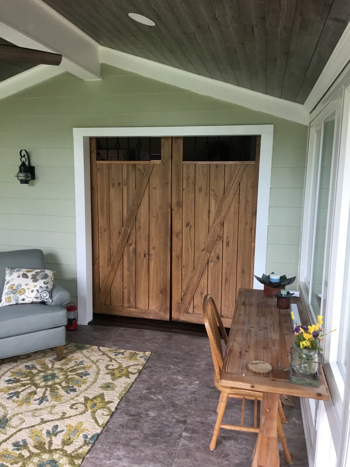 Sunroom with sliding barn doors and wide-plank floors