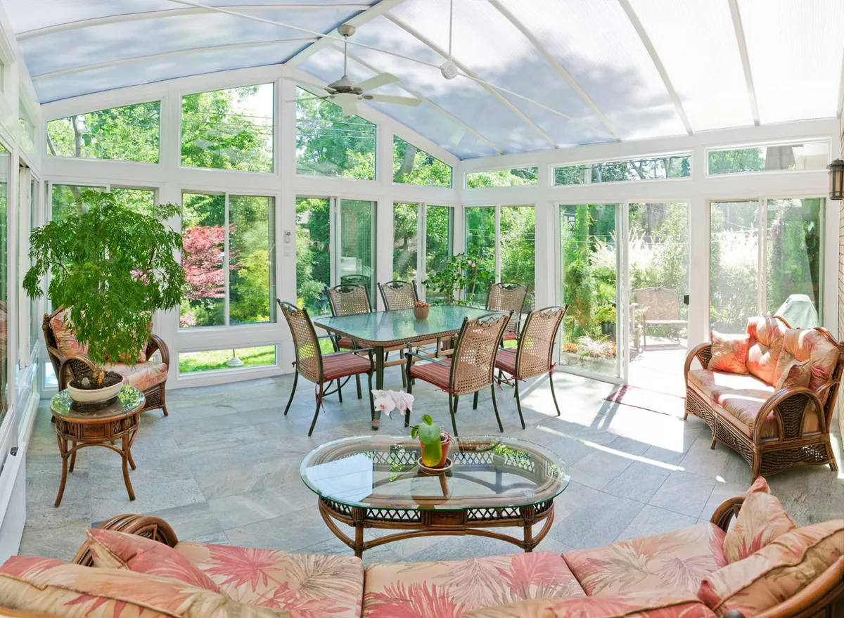 Sunroom set for dining and lounging among potted plants