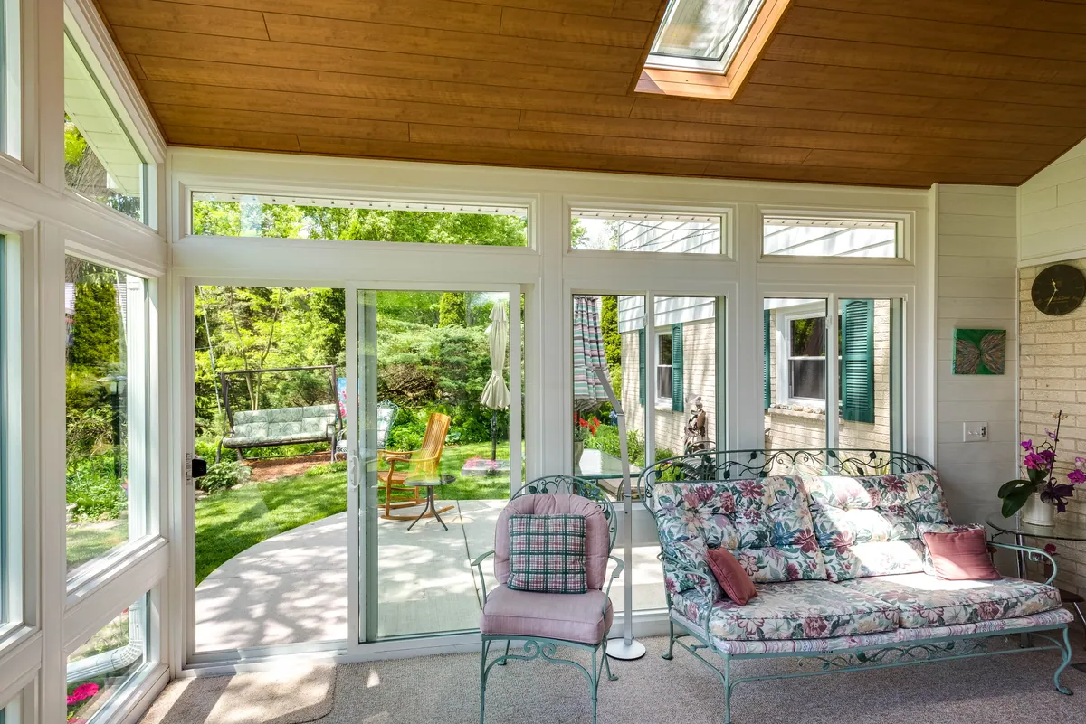 Sunroom with a wood ceiling and skylight opening to the garden