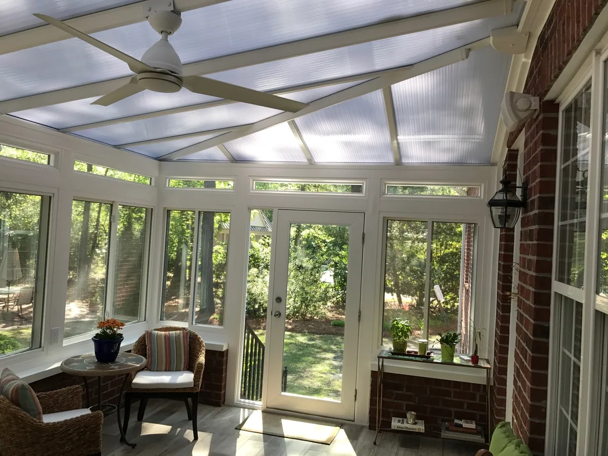 Glass-roof sunroom furnished with wicker seating