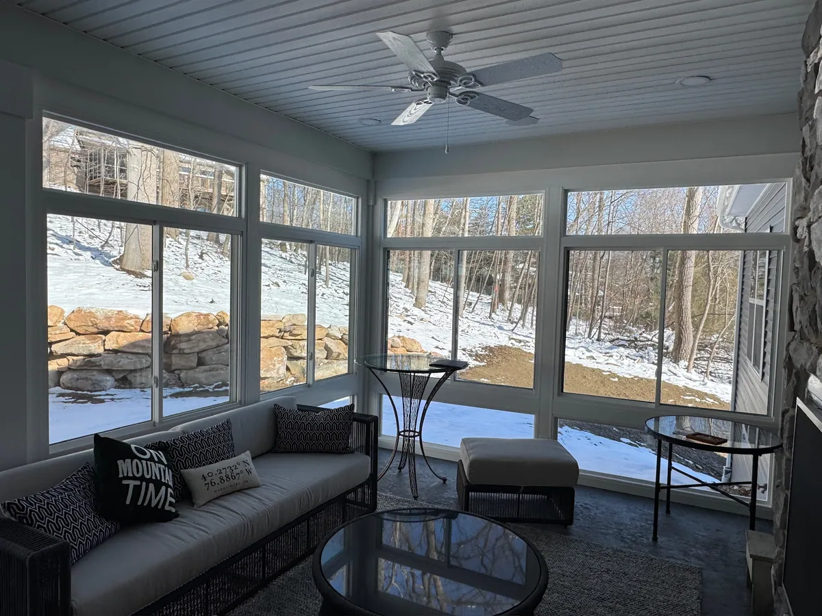 Grey-ceiling sunroom with a round coffee table in winter