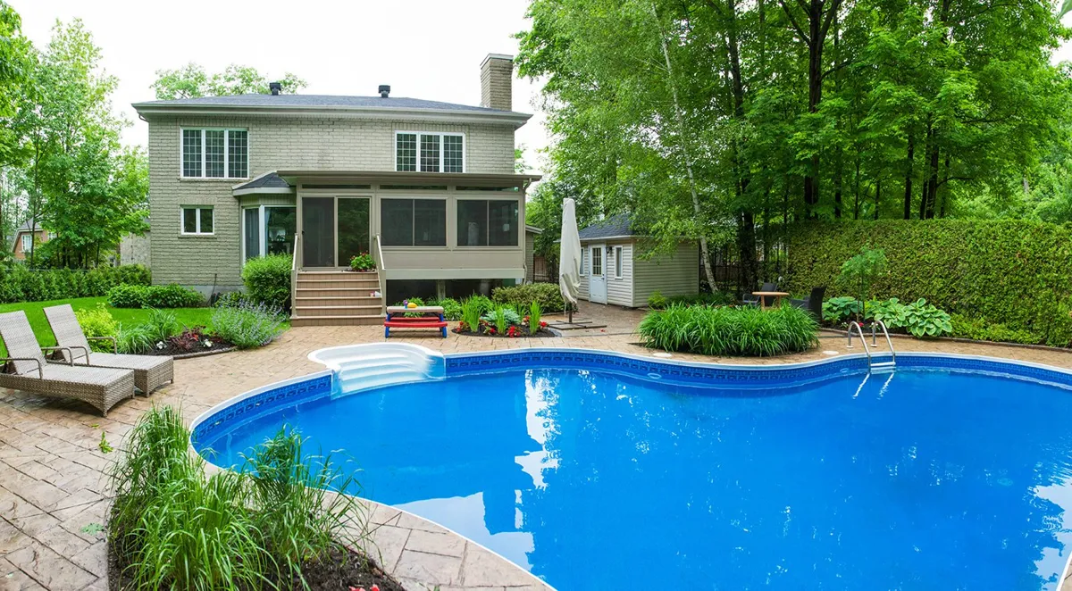 Sunroom beside a backyard pool