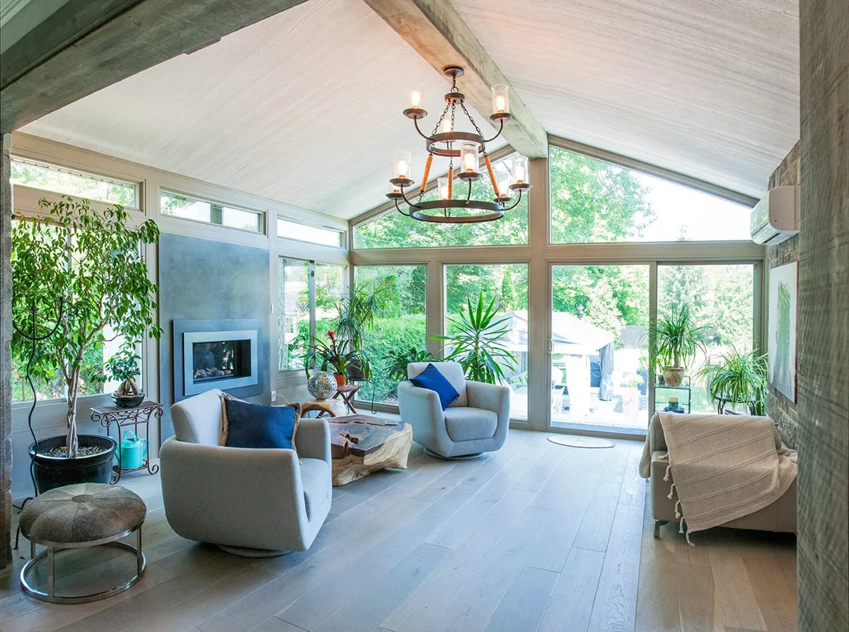 Sunroom interior with chandelier and wall of windows