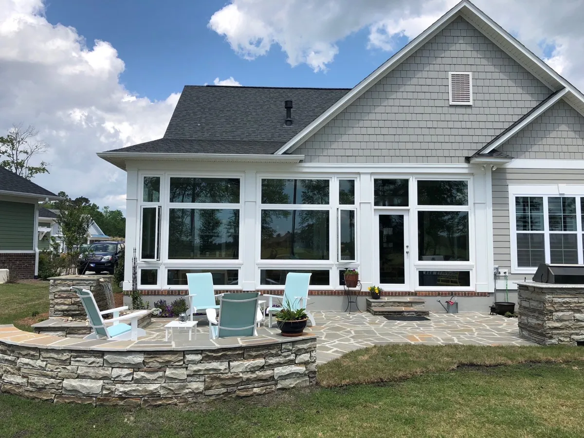 White sunroom addition with fire pit patio