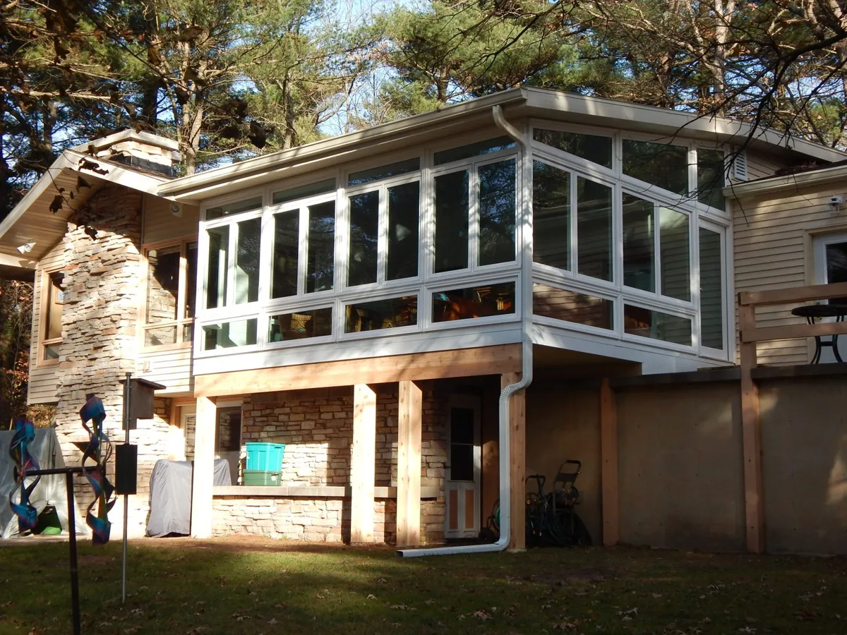 Second-storey room addition on a stone base, built into the back of the house